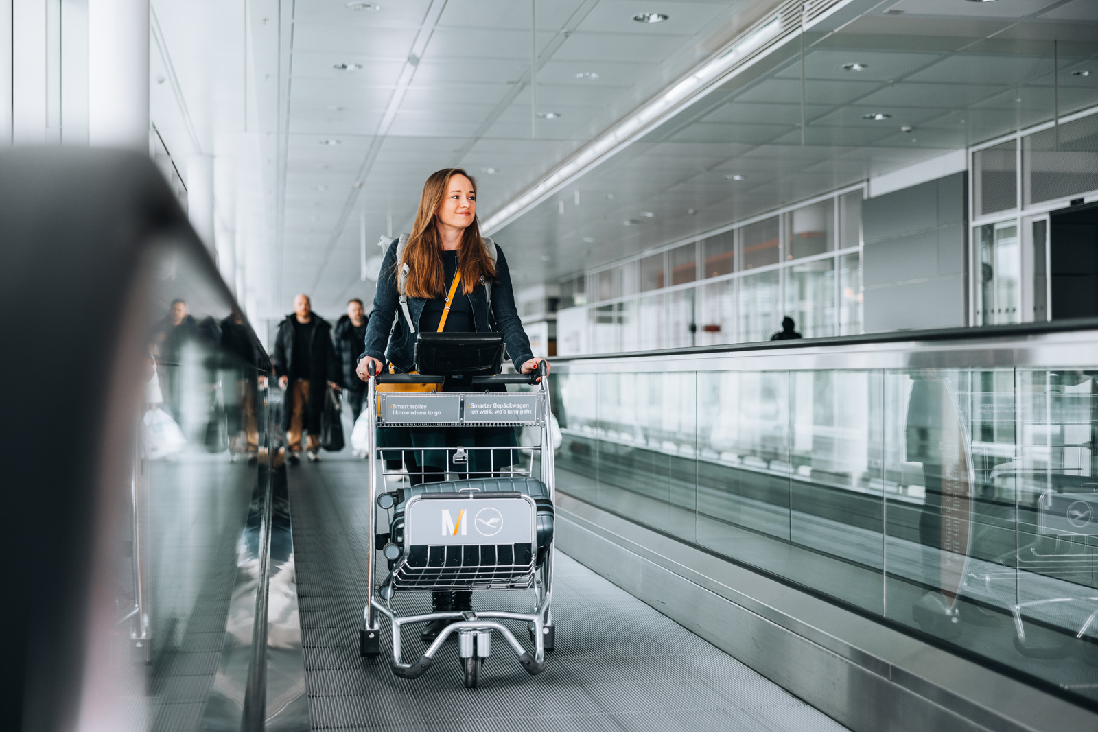 Das Bild zeigt smart trolleys am Flughafen München mit einer Mitarbeiterin. Businessfotografie für eine Kampagne in München.
